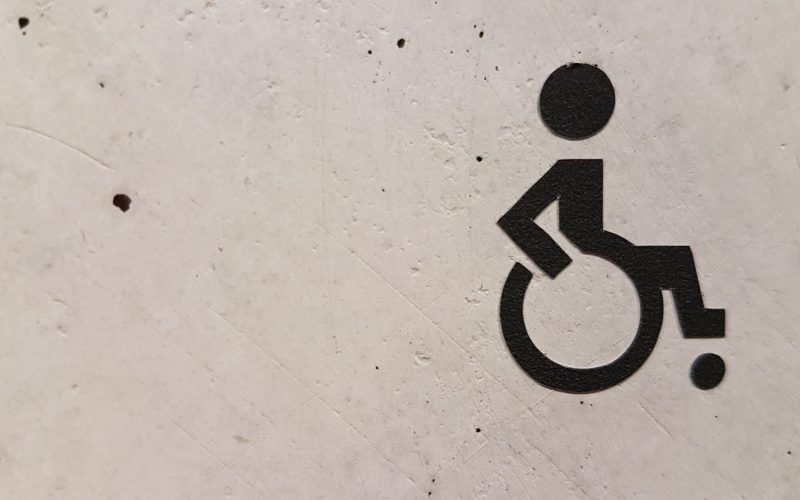 Symbole handicapé sur un mur blanc