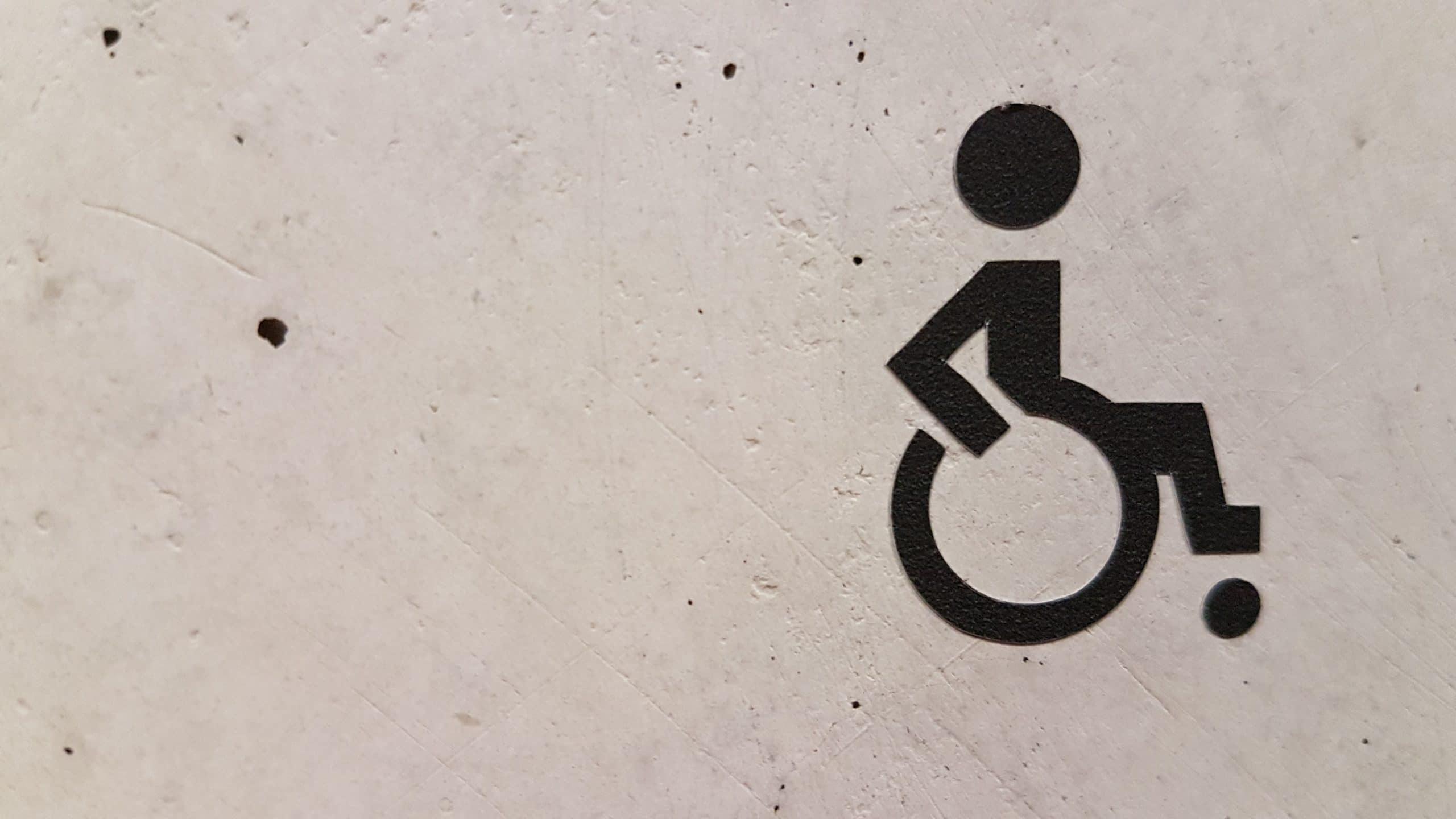 Symbole handicapé sur un mur blanc